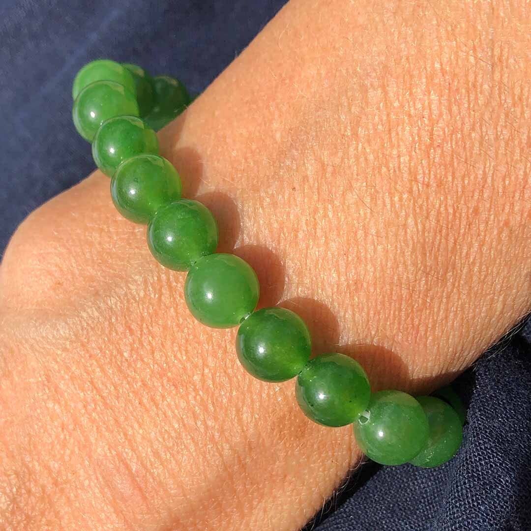 Hand displaying 8mm Green Jade Hand displaying 8mm Green Jade