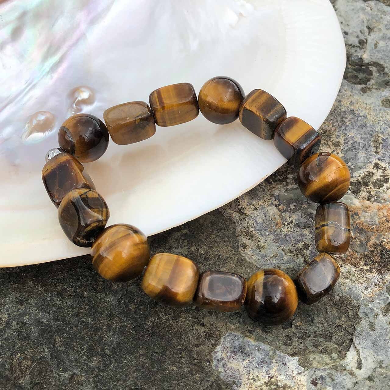 Tiger's ye 14mm Bead Bracelet resting on shell Tiger's ye 14mm Bead Bracelet resting on shell