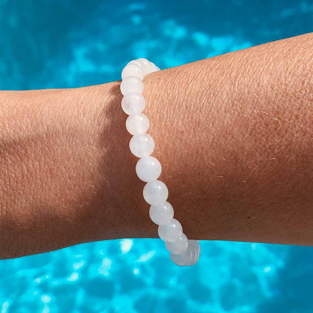 Hamd displaying 6mm White Jade Bracelet with pool behind Hamd displaying 6mm White Jade Bracelet with pool behind