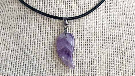 Chevron Amethyst wing pendant on a jute background