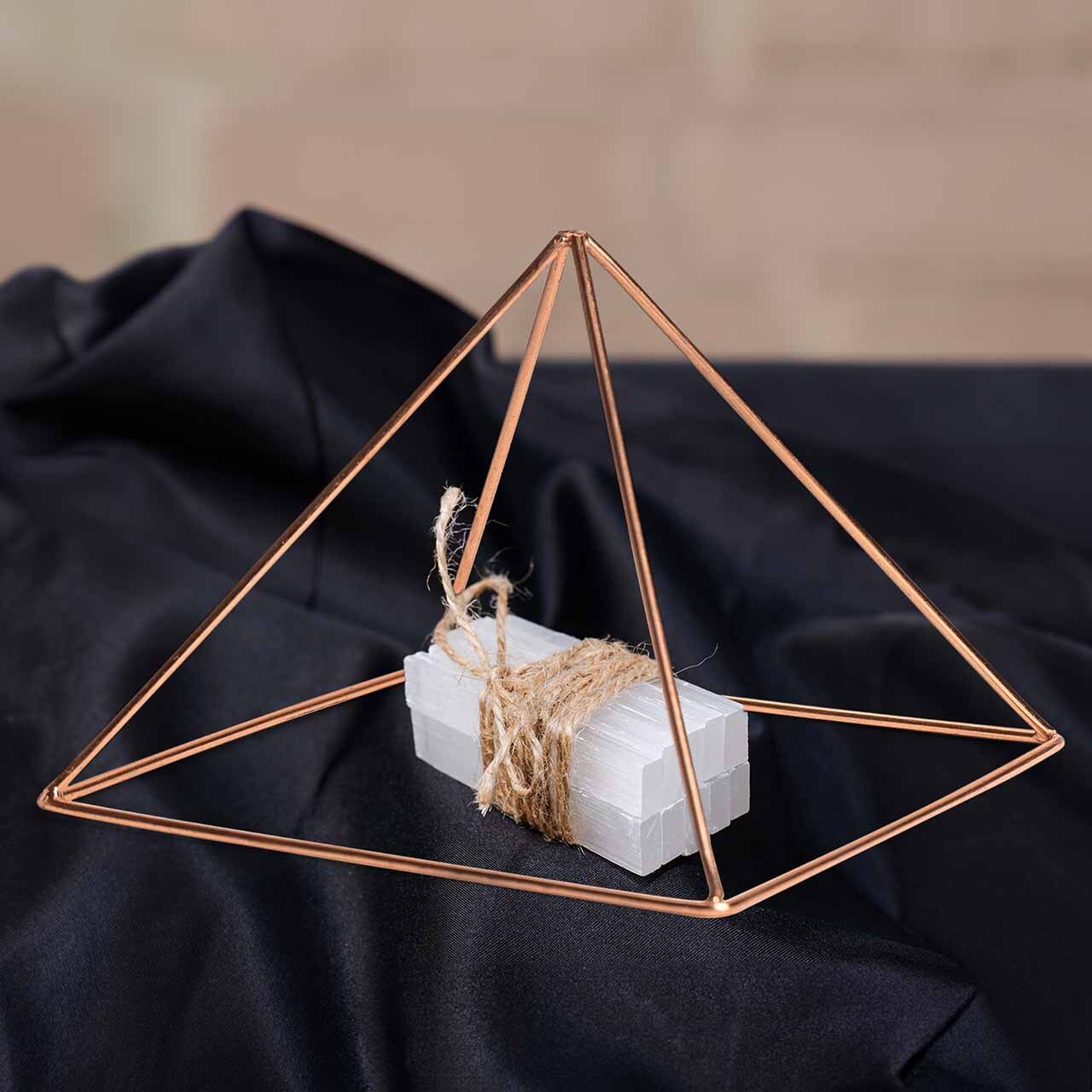 Copper wire oyramid and selenite on black velvet