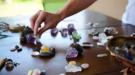 Hand choosing a crystal from selection on table