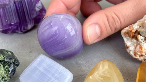 Hand selecting a purple crystal