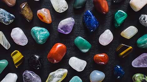 Range of tumbled gemstones laying on table