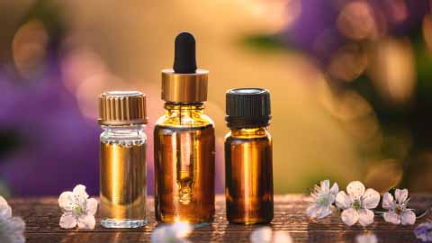 Essential oil bottles on board with flowers