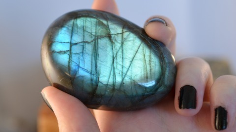 Hand holding a labradorite palm stone