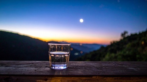 Moonlit glass of water on outside ledge Moonlit glass of water on outside ledge