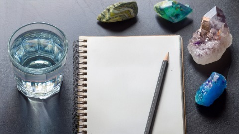 Study notebook pencil with crystals and water glass